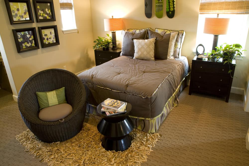 We start off with a majestic bedroom that blends brown color with orange hue. The black frames on the wall, the black unique wicker round chair, shaggy rug and black table catches the eyes easily.
