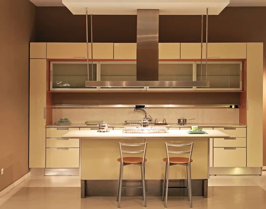 Modern kitchen with a light accent . The cabinet is brilliant with light oatmeal color and white countertop. The shining cabinet steel finished handles and outer rims  add enunciation to the kitchen .