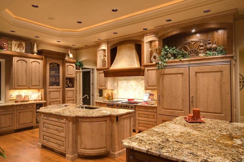 A rustic kitchen that makes use of natural wood . The wooden color complements the granite countertop.