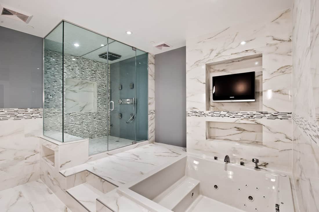 This is another example of elegant usage of marble in a modern bathroom . With the arrangement shown , you can turn your master bath into a cozy spa.