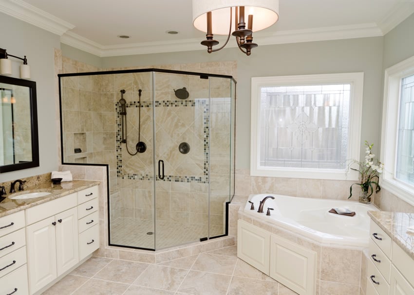 A chic bathroom that uses glazed ceramic tiles for the floors and walls. Some elements of diagonality is introduced in the glass border of shower area and the bathtub. The vanity is white with cream granite countertop. The black utensils used in the show area makes the area quite artistic.
