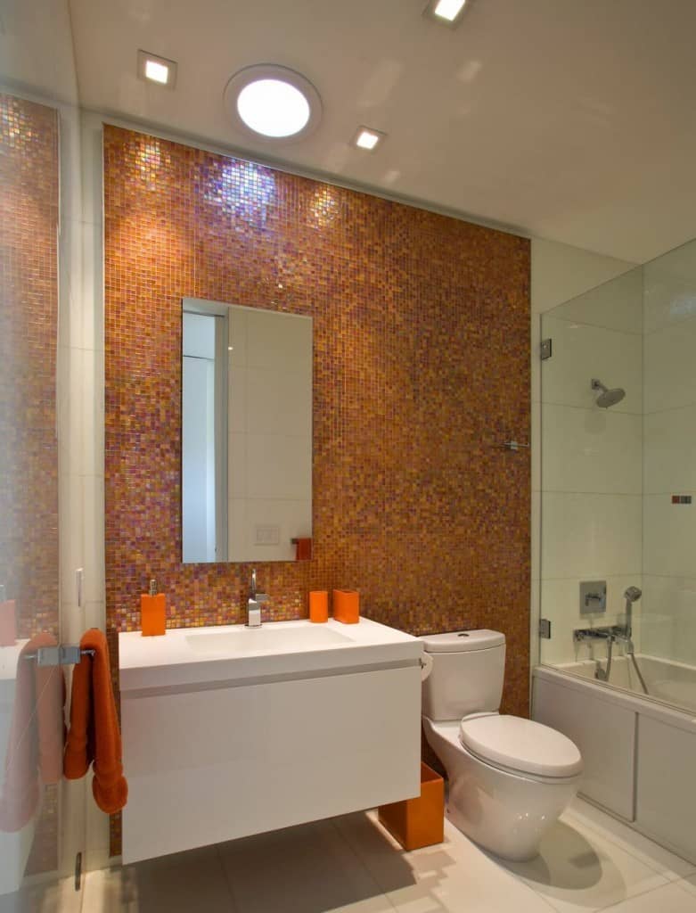 The red and orange accent mosaic wall sets the tone for this modern kitchen. The other parts of the bathroom is white and simple.