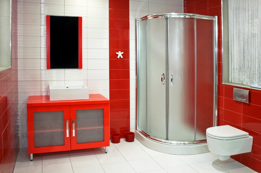 A striking red and white bathroom design with the shower enclosure placed at the corner.