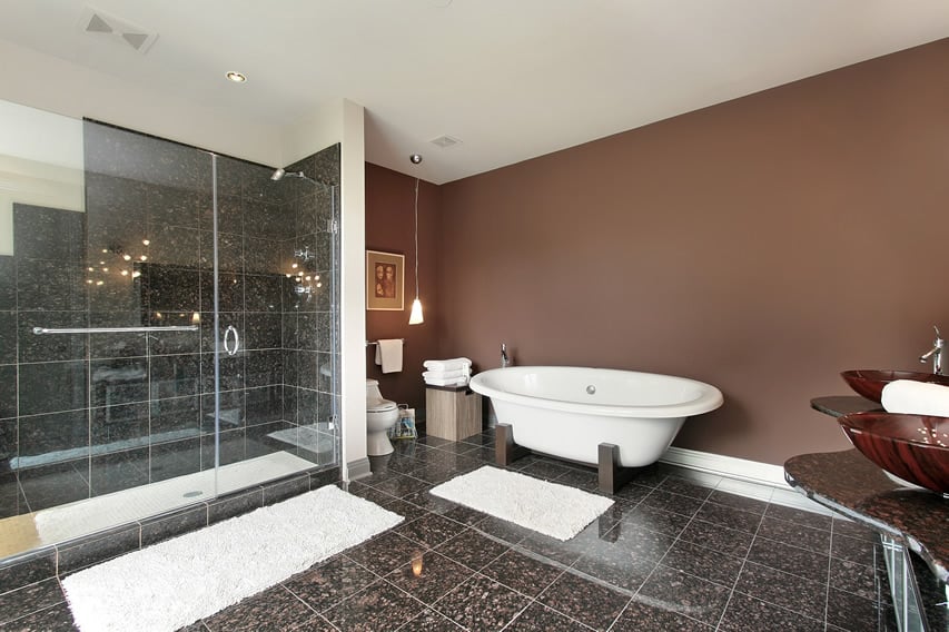 This modern bathroom uses medium porcelain tiles in floor and shower area. The wall surrounding the bathtub has solid sandrift color.