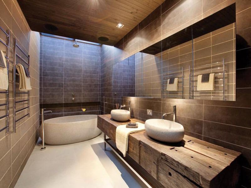 This bathroom has a combination of rustic and modern style. The wooden vanity, stone sink and stone wall tiles combined with other modern features to finalize this awesome bathroom.