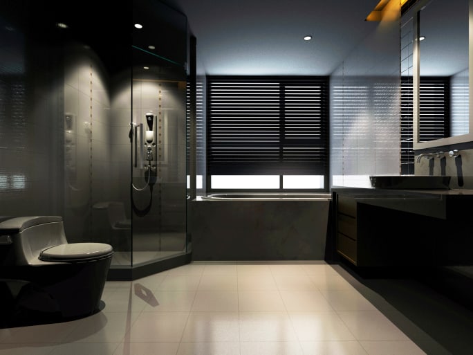 A large masculine bathroom with black stratosphere. The shower area is enclosed with glass.