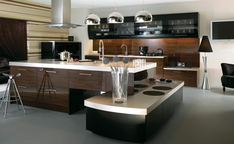 A unique  ultra-modern kitchen with L-shaped cabinets placed in different elevations. The main backsplash is wooden where the countertop is on different elevations as well. The countertops are covered with white laminates.