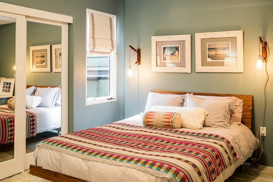 A bright and playful bedroom with jolly color combinations. The use of natural wood , linens and light fixtures bring in little bit of rusticity.